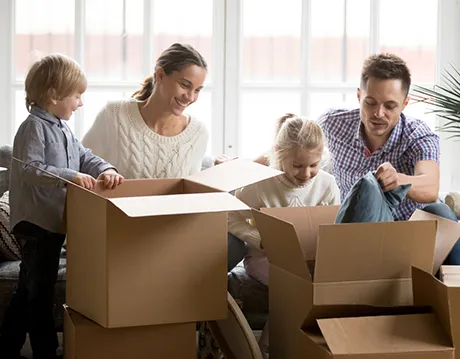 young family opening moving boxes