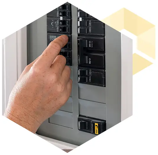 photo of a person's hand flipping a switch in an electrical breaker box